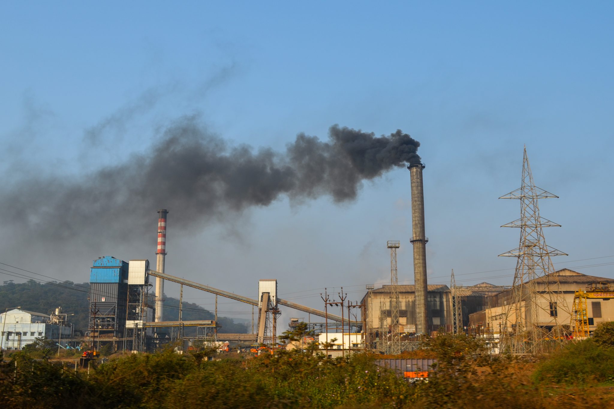 A large industrial sugar factory with chimneys and conveyors